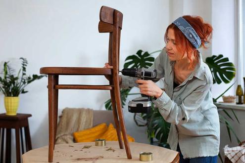 Women decorating new wooden chair